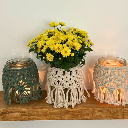 Makramee Windlichter auf Holzbrett mit kerzen und blumen