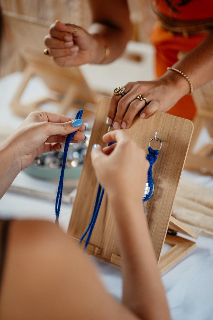 Joana erklärt Makramee Knoten beim kreativen Workshop, Frau knotet Makramee Discokugel Anhänger