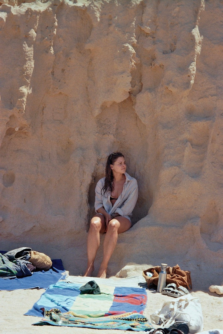 Frau sitzt am Strand im Felsen beim Mallorca Retreat