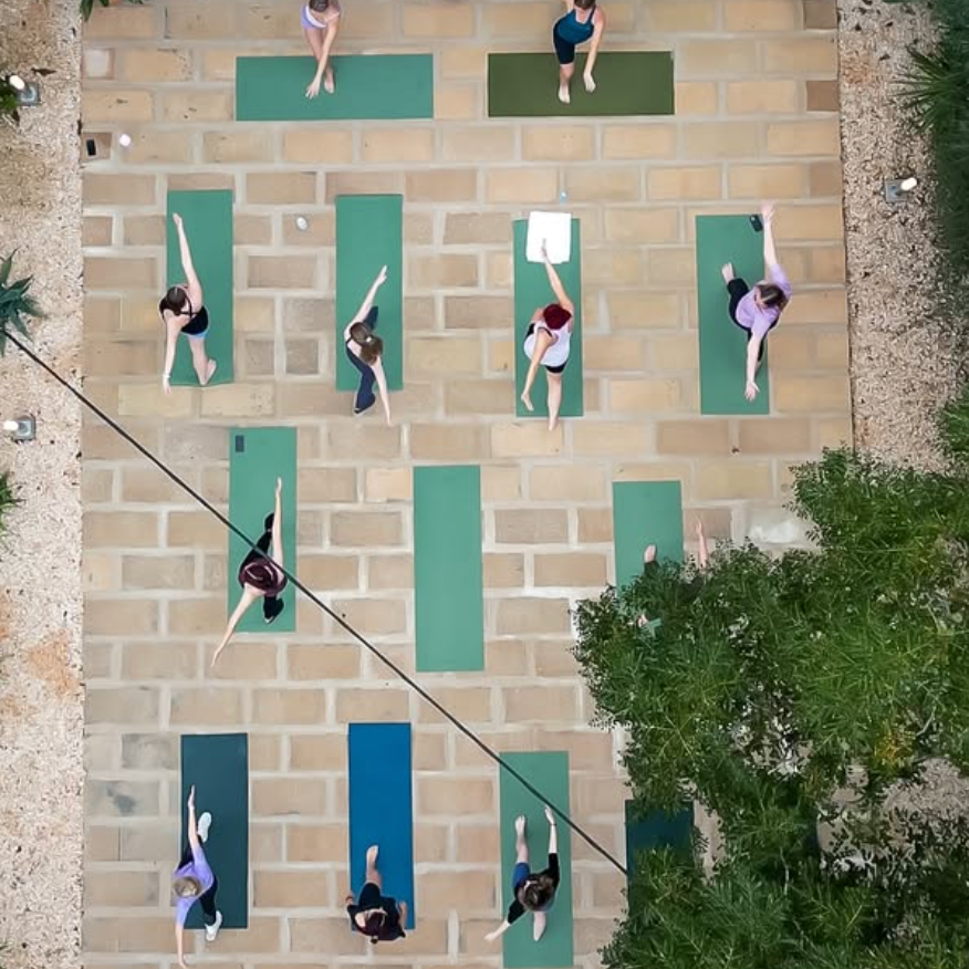 Yoga draußen auf grünen Matten beim Noué Retreat auf Mallorca im Zenara