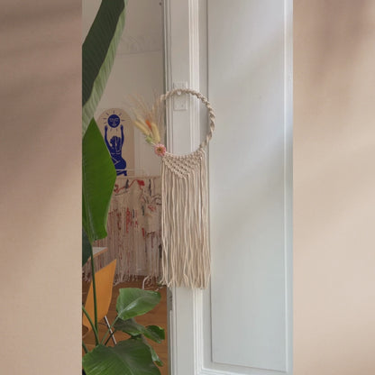 Makramee Kranz mit Trockenblumen vor weißer Wand
